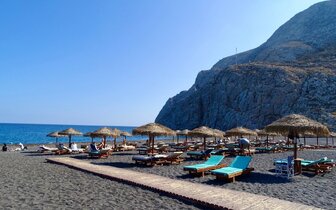 Santorini - Kamari beach - pláž s čiernym vulkanickým pieskom