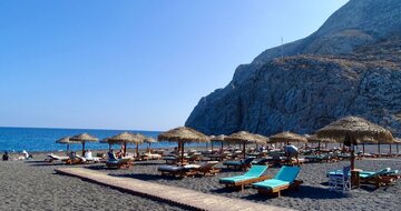 Santorini - Kamari beach - pláž s čiernym vulkanickým pieskom